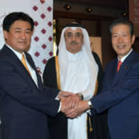 Ambassador of the State of Qatar Hassan Bin Mohammed Rafei Al-Emadi (center) poses with Special Advisor to the Prime Minister Minoru Kihara (left) and President of Komeito and Member of the House of Councillors Natsuo Yamaguchi (right) during      a reception celebrating the national day of Qatar at the Imperial Hotel on Dec. 12. | YOSHIAKI MIURA