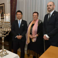 Ambassador of Israel Yaffa Ben-Ari (center) poses with Parliamentary Vice-Minister for Foreign Affairs Shinichi Nakatani (left) and Culture and Science Affairs Attache of the Embassy of Israel Arieh Rosen during a Hanukkah candle lighting reception at the ambassador\'s residence on Dec. 25. | YOSHIAKI MIURA
