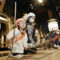 Volunteers hit tatami with bamboo sticks during the annual year-end cleanup at Nishi-Honganji, a temple in Kyoto\'s Shimogyo Ward, on Friday. The tradition, which goes back more than 500 years, is meant to celebrate the peaceful passing of another year and prepare for a new year. About 600 people dressed in coverall aprons helped clean the mats at the temple\'s Founder\'s Hall. | KYODO