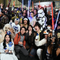 \"Star Wars\" fans wait excitedly Thursday outside a theater for a screening of \"Star Wars: The Rise of Skywalker\" in Tokyo\'s Roppongi district. Nearly 1,000 fans gathered at the theater for the ninth episode of the original \"Star Wars\" saga, which opens in theaters Friday. | SATOKO KAWASAKI