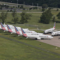 Grounded Boeing 737 Max jets belonging to American Airlines are stored at Tulsa International Airport in Tulsa, Oklahoma, last May. American Airlines said Jan. 2 it is negotiating with Boeing over compensation for the airline\'s grounded planes and will share some of the proceeds with its employees. | TOM GILBERT / TULSA WORLD / VIA AP