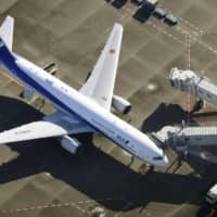 A chartered All Nippon Airways flight repatriating Japanese nationals from virus-hit Wuhan in China arrives at Haneda Airport in Tokyo on Wednesday. The airline said the same day it will extend throughout February the suspension of all flights between Wuhan and Narita International Airport in Chiba Prefecture. | KYODO