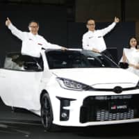 Toyota Motor Corp.\'s GR Yaris is unveiled at the Tokyo Auto Salon trade show held at Makuhari Messe convention center in Chiba Prefecture on Friday. Toyota President Akio Toyoda is at left. | KYODO