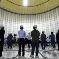A ceremony is held inside a liquefied natural gas storage tank under construction at Tokyo Electric Power Co.\'s gas-fired thermal power plant in Futtsu, Chiba Prefecture, in September. | BLOOMBERG