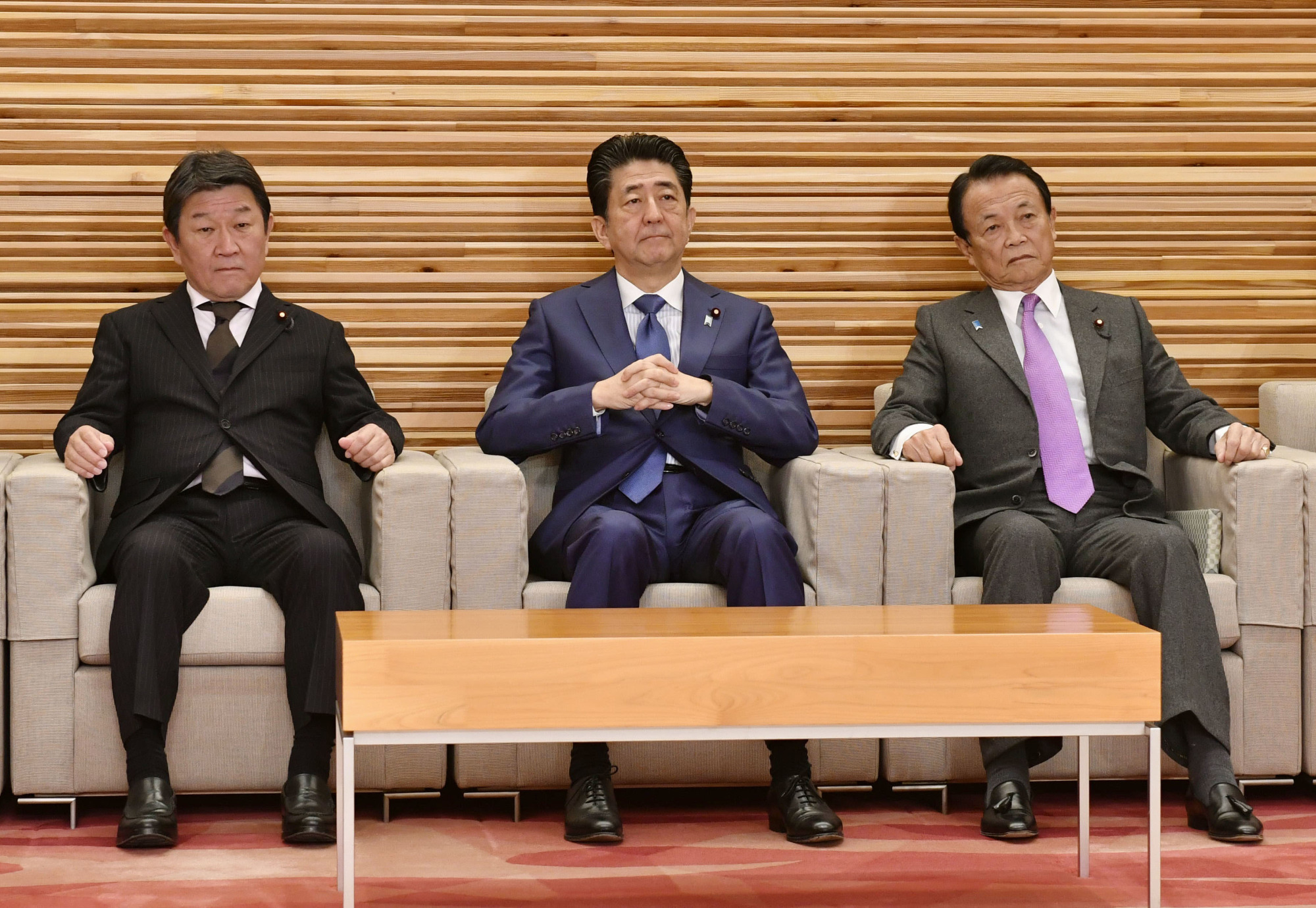 Flanked by Foreign Minister Toshimitsu Motegi (left) and Finance Minister Taro Aso, Prime Minister Shinzo Abe attends a Cabinet meeting Friday to approve bills on a tax reform package for fiscal 2020. | KYODO
