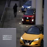 A Nissan Motor Co. Leaf electric vehicle (front) is displayed outside the company\'s Yokohama headquarters on Jan. 9. | BLOOMBERG
