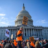 Protesters gather near the U.S. Capitol on Wednesday as they rally against U.S. President Donald Trump in Washington. Both sides spent the last week presenting their cases for and against President Trump, who is accused of abuse of power and obstruction of Congress, as well as the constitutional underpinnings of the charges. | AFP-JIJI