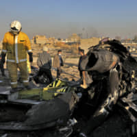 Rescue workers search the scene where a Ukrainian plane crashed in Shahedshahr, southwest of the capital Tehran, Wednesday. The Ukrainian airplane crashed on Wednesday shortly after takeoff from Tehran\'s main airport, killing all 176 onboard. | AP