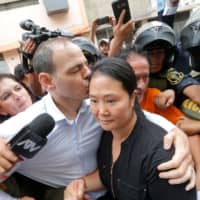 Peruvian politician Keiko Fujimori is kissed by her husband, Mark Villanella, on arriving at court in Lima on Jan. 20. | AFP-JIJI