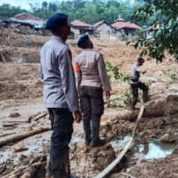 Rescuers search for victims after a landslide in Cigudeg, West Java, on Friday. | AP