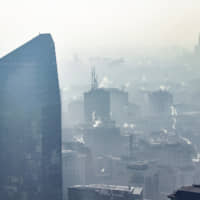 A view from above of downtown Milan, Italy, shows smoke coming from heating systems. The heavy pollution from atmospheric aerosol particles, microscopic solid or liquid matter suspended in the air, led to a partial stop of urban traffic. | CLAUDIO FURLAN / LAPRESSE / VIA AP