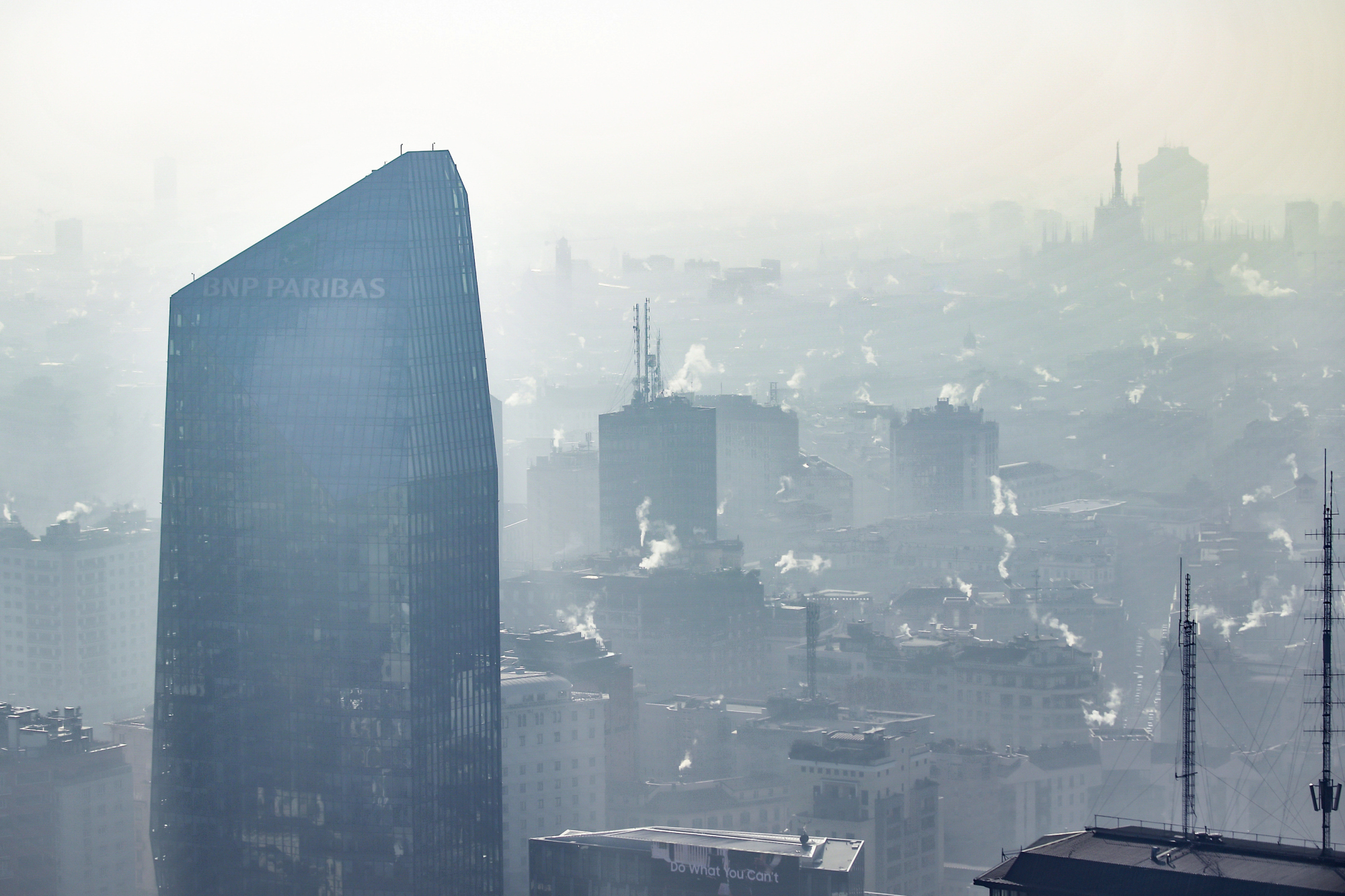 A view from above of downtown Milan, Italy, shows smoke coming from heating systems. The heavy pollution from atmospheric aerosol particles, microscopic solid or liquid matter suspended in the air, led to a partial stop of urban traffic. | CLAUDIO FURLAN / LAPRESSE / VIA AP