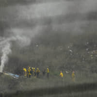 Firefighters work the scene of a helicopter crash that killed former NBA basketball player Kobe Bryant Sunday in Calabasas, California. | AP