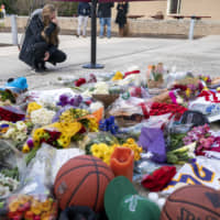 A woman is emotional at the scene of a small memorial left in remembrance to Kobe Bryant at the entrance of the Bryant Gymnasium at Lower Merion High School Monday in Wynnewood, Pennsylvania. The 41-year-old Bryant and his 13-year-old daughter, Gianna, were among nine people who died in the crash in Calabasas, California, in foggy weather conditions Sunday morning. | AP