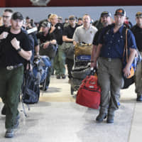 A contingent of 39 firefighters from the United States and Canada arrive at the airport in Melbourne on Thursday. The firefighters will assist local crews with ongoing fires burning across the state of Victoria. | AP
