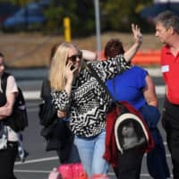 Evacuees, together with a cat, arrive at the Somerville Recreation Centre in Somerville, southeast of Melbourne, on Saturday. They were transported to the port of Hastings on the Australian Navy vessel MV Sycamore from the bush fire-hit town of Mallacoota in the state of Victoria. | REUTERS