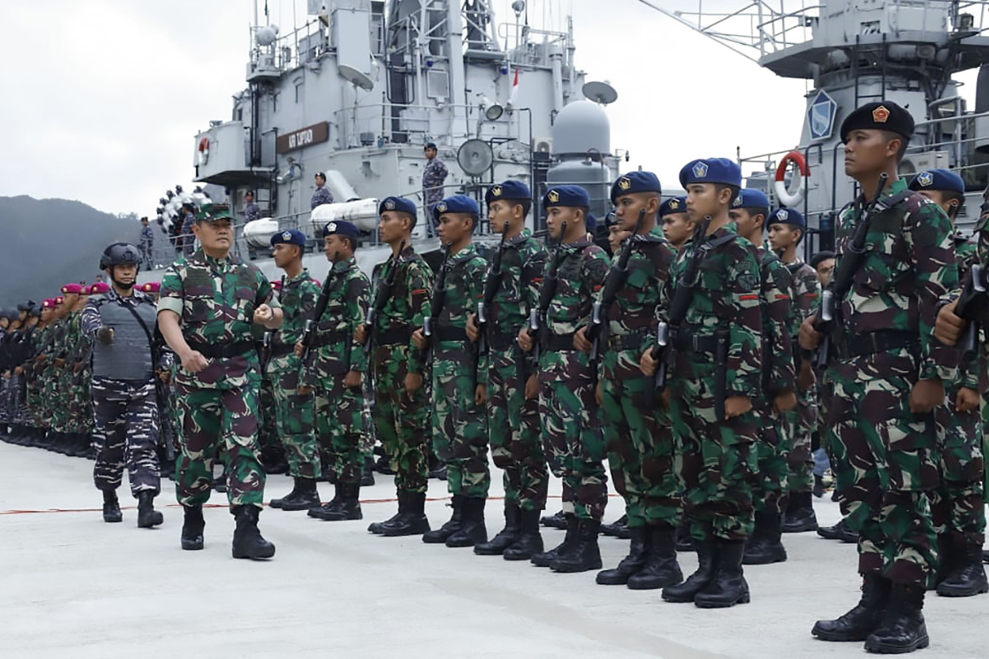 The commander of region 1 of defense territory joint command, Rear Adm. Yudo Margono (front left), inspects Indonesian troops at the Natuna military base in Riau islands Friday. Indonesia is stepping up sea and aerial patrols of islands near the disputed South China Sea, an official said Saturday following a diplomatic spat over 'trespassing' Chinese vessels. | HANDOUT / INDONESIAN ARMED FORCES (TNI) / VIA AFP-JIJI