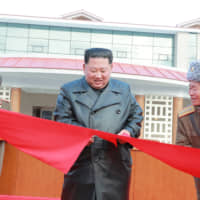North Korean leader Kim Jong Un cuts a ribbon during a ceremony for the completion of the Yangdok County Hot Spring Cultural Recreation Center in North Korea in this undated picture released Dec. 7. | KCNA / VIA REUTERS