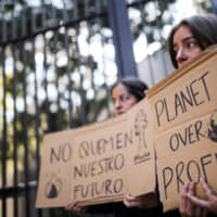 Activists hold signs in a protest over Australia\'s bush fire crisis, outside the Australian Embassy in Mexico City on Friday. | REUTERS
