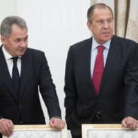 Russian Defense Minister Sergei Shoigu (left) and Foreign Minister Sergey Lavrov talk prior a meeting with Saudi Deputy Crown Prince and Defense Minister Mohammed bin Salman in Moscow\'s Kremlin in 2017. Lavrov and Shoigu have retained their jobs. | PAVEL GOLOVKIN / POOL / AP