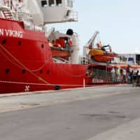 Migrants leave the Ocean Viking ship at the port of Pozzallo in Sicily, Italy, in October. | REUTERS