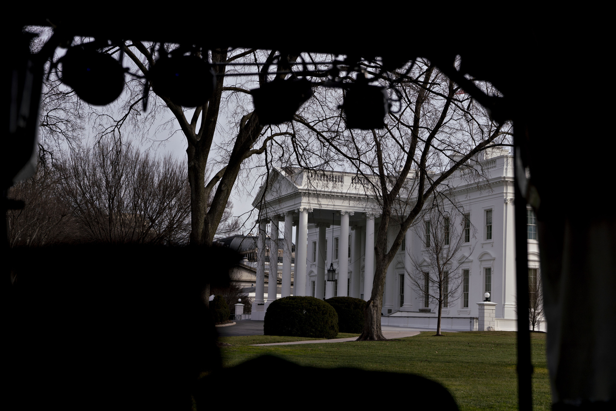 The White House is seen Thursday beyond television equipment in Washington. House Speaker Nancy Pelosi and Senate Majority Leader Mitch McConnell are locked in a stare-down over the terms of President Donald Trump's impeachment trial, which carries political risks for both sides if it continues deeper into January. | BLOOMBERG