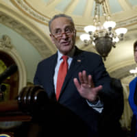 Senate Minority Leader Chuck Schumer, accompanied by Sen. Tammy Baldwin, peaks during a news conference outside of the Senate chamber, on Capitol Hill in Washington Tuesday. | AP