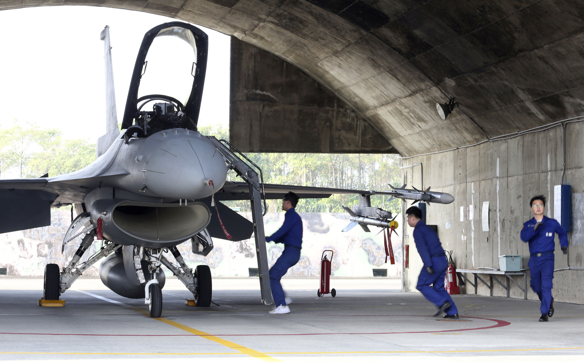 Ground crew of the Taiwan air force run to a U.S. made F-16V fighter for its emergency takeoff during a military exercise in Chiayi County, southern Taiwan, Wednesday. Taiwan military started a two-day joint forces exercises on Wednesday to show its determination to defend itself from Chinese threats. | AP