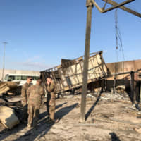 U.S. soldiers are seen at the site where an Iranian missile hit at Ain al-Asad air base in Anbar province, Iraq, Monday. | REUTERS