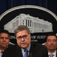 U.S. Attorney General, William Barr (center) and FBI Deputy Director David Bowdich (left) hold a press conference regarding the December shooting at the Pensacola Naval air station in Florida, at the Department of Justice in Washington Monday. The United States will send 21 Saudi military trainees back to the Gulf kingdom after an investigation into the fatal shooting of three American sailors last month, the Justice Department announced Monday. | AFP-JIJI