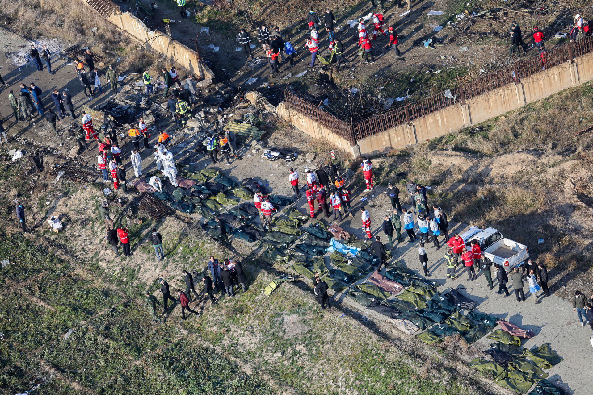 People and rescue teams are seen Wednesday amid bodies and debris after a Ukrainian plane carrying 176 passengers crashed near Imam Khomeini airport in the Tehran, killing everyone on board. | ROUHOLLAH VAHDATI / ISNA / VIA AFP-JIJI