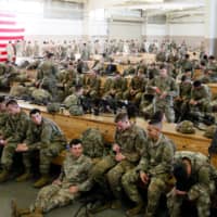 U.S. Army paratroopers assigned to 1st Brigade Combat Team, 82nd Airborne Division prepare to board an aircraft bound for the U.S. Central Command area of operations from Fort Bragg, North Carolina, on Sunday. | HANDOUT VIA REUTERS