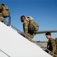 U.S. Army paratroopers assigned to 1st Brigade Combat Team, 82nd Airborne Division board an aircraft bound for the U.S. Central Command area of operations from Fort Bragg, North Carolina, on Sunday. | VIA REUTERS