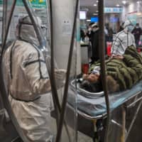 A patient is wheeled into the Wuhan Red Cross Hospital in the Chinese city Saturday. | AFP-JIJI