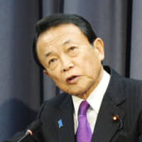 Finance Minister Taro Aso speaks at a news conference at the ministry in Tokyo on Tuesday. | KYODO