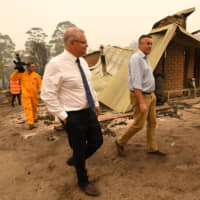 Australian Prime Minister Scott Morrison visits a farm in Sarsfield, Victoria, on Friday that was burned by a bush fire. | GETTY IMAGES