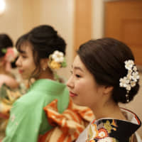 Ayana Fukushima (right) and her friends get ready for a coming-of-age ceremony at the Imperial Hotel in Tokyo on Monday. | RYUSEI TAKAHASHI