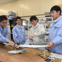 Students belonging to Nagoya City Technical High School\'s airplane club create a cardboard model of a seaplane they are planning to develop for disaster rescue. | CHUNICHI SHIMBUN
