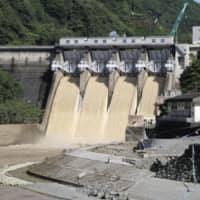 Kanogawa Dam in Ozu, Ehime Prefecture, conducted an emergency discharge of water during torrential rain that fell in the area in 2018. | KYODO