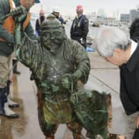 A statue of Ebisu, which was found underwater off Kesennuma port in Miyagi Prefecture, was pulled from the sea on Tuesday. | KYODO