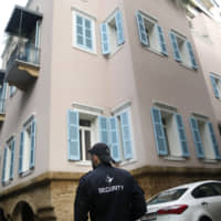 A private security guard stands outside the house of ex-Nissan chief Carlos Ghosn in Beirut Sunday. | AP