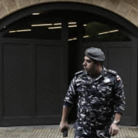 A policeman leaves the residence of former Nissan Chairman Carlos Ghosn on Tuesday in Beirut. A close friend says Ghosn, who was awaiting trial in Japan, has arrived in Beirut. It was not clear how Ghosn, who is of Lebanese origins, left Japan where he is under surveillance and is expected to face trial in April. | AP