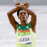 Ethiopian marathon runner Feyisa Lilesa crosses his arms above his head at the finish line during the 2016 Rio de Janeiro Olympics in Rio de Janeiro, Brazil, on Aug. 21, 2016. | GETTY IMAGES / VIA KYODO
