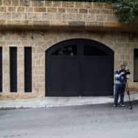 An international media representative films outside the property of Carlos Ghosn, former head of Nissan Motor Co. and Renault SA, in Beirut on Tuesday. | BLOOMBERG