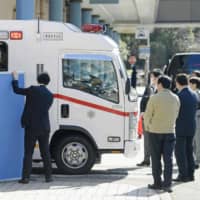An ambulance carrying Japanese people who flew from Wuhan by a government-chartered plane arrives at a hospital in Tokyo\'s Ota Ward on Thursday. | KYODO