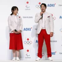 Swimmer Daiya Seto (right) shows off the uniform of the Japanese national team to be worn by athletes during the opening ceremonies for the Olympic and Paralympic Games, alongside weightlifter Hiromi Miyake (left) and equestrian Akane Kuroki on Thursday in Tokyo. | KYODO