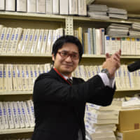 Kenta Miyahara, a political reporter for the Mainichi Shimbun, celebrates the 1,000-subscriber mark for his nascent YouTube channel during a video shoot in Tokyo on Dec. 12. | TOMOHIRO OSAKI