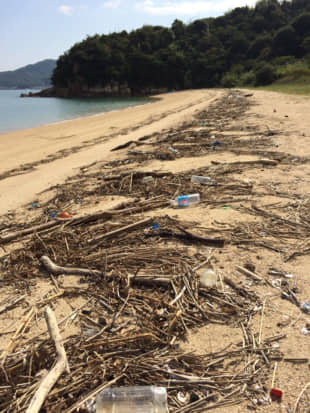 Drifting onto the shore: Plastic garbage washes ashore with more natural debris prompting the residents of Shiraishi Island to take part in regular beach cleanups. | AMY CHAVEZ