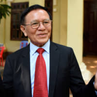 Kem Sokha, former leader of the now-banned Cambodia National Rescue Party (CNRP), speaks to the media as he departs his residence for the Phnom Penh municipal court for the start of his trial on Jan. 15, more than two years after his arrest on treason charges. | AFP-JIJI