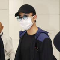 Kento Momota arrives at Narita International Airport on Wednesday after he was released from a Malaysian hospital following an injury in a vehicle collision earlier this week. | KYODO